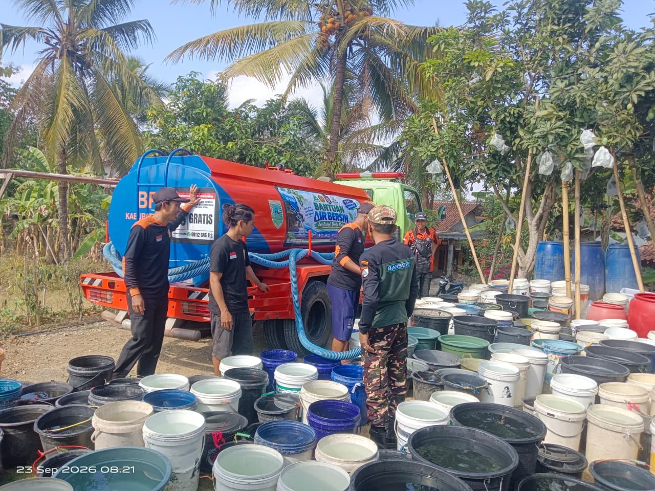 Relawan dan Banser mengisi ember penampungan warga dengan air bersih dari truk tangki di Kebumen